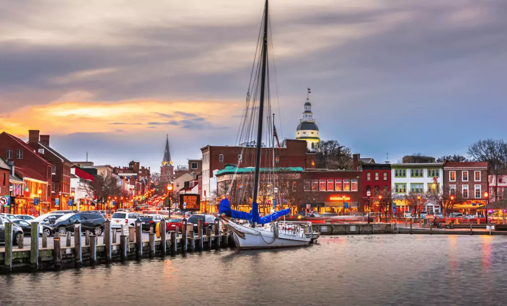 boat in the harbor surrounded buildings and cars parked along the harbor sidewalk at dusk is a great place to visit after getting your medical card