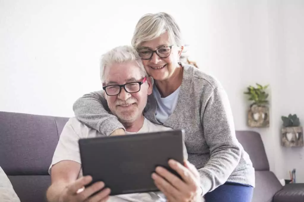 couple sitting on the couch looking at a tablet to get medical card online