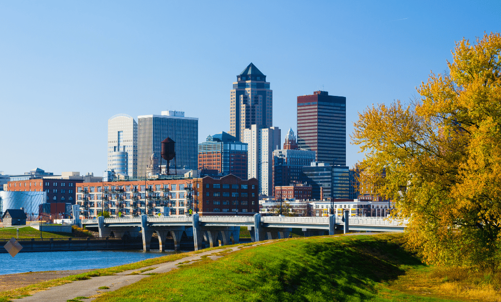 downtown des monies iowa with buildings along the river with a bridge on a sunny day is a great place to visit after getting your medical card