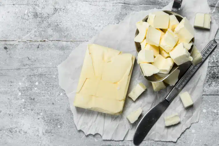 butter in a bowl with a knife. on a rustic background preparing to make cannabutter