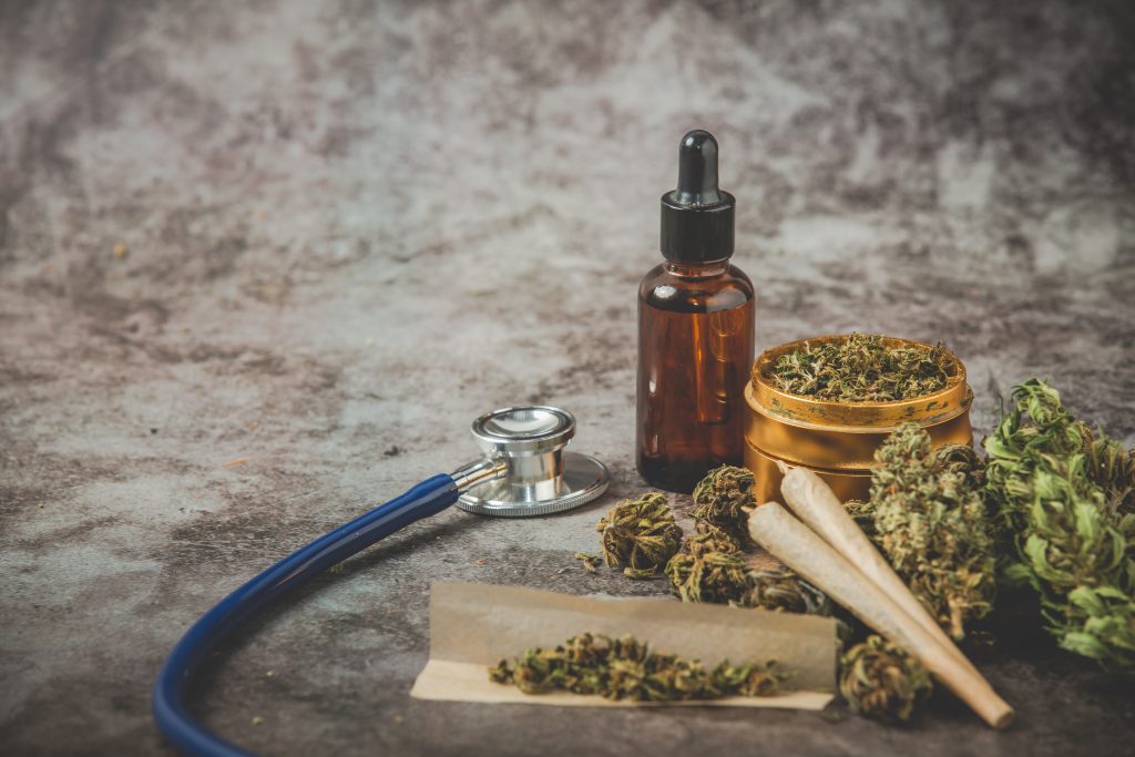 metal grinder weed,canabis oil and joint on gray background