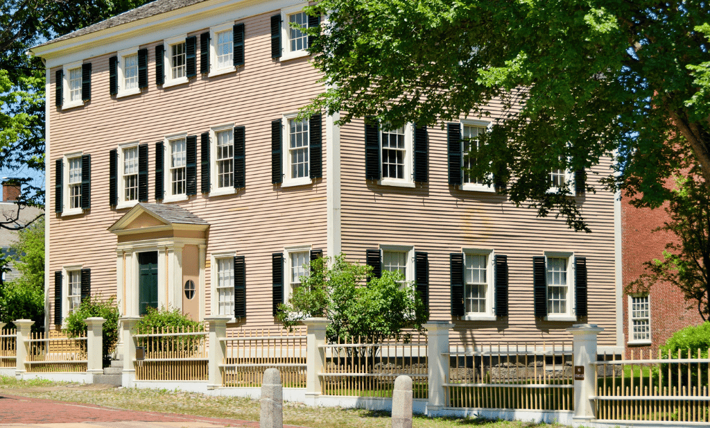 Old fashioned tan home with dark shutters in Salem Massachusetts is a great place to visit after getting your medical card